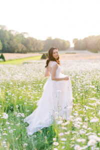 bride running in a wildflower fields at chateau de champlatreux near Paris